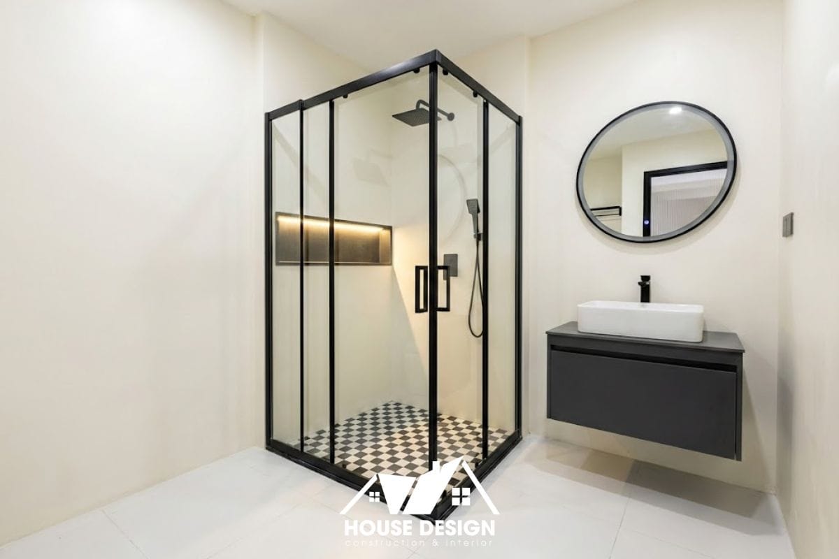 Thiết kế nhà vệ sinh chung cư phong cách tối giản với tông màu trắng, sàn gạch caro và khung kính đen.