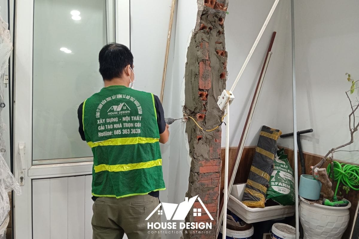 Kỹ thuật viên của House Design đang thực hiện công tác phá dỡ tường gạch để chuẩn bị mặt bằng cải tạo, đảm bảo an toàn kết cấu.