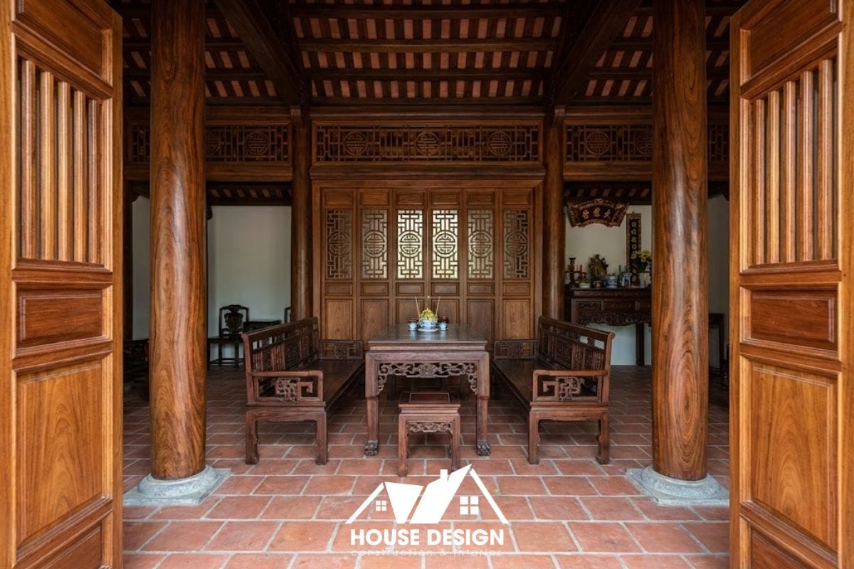 Gian giữa nhà gỗ 3 gian được bố trí bộ trường kỷ gỗ gụ sang trọng, sàn lát gạch Bát Tràng thủ công.