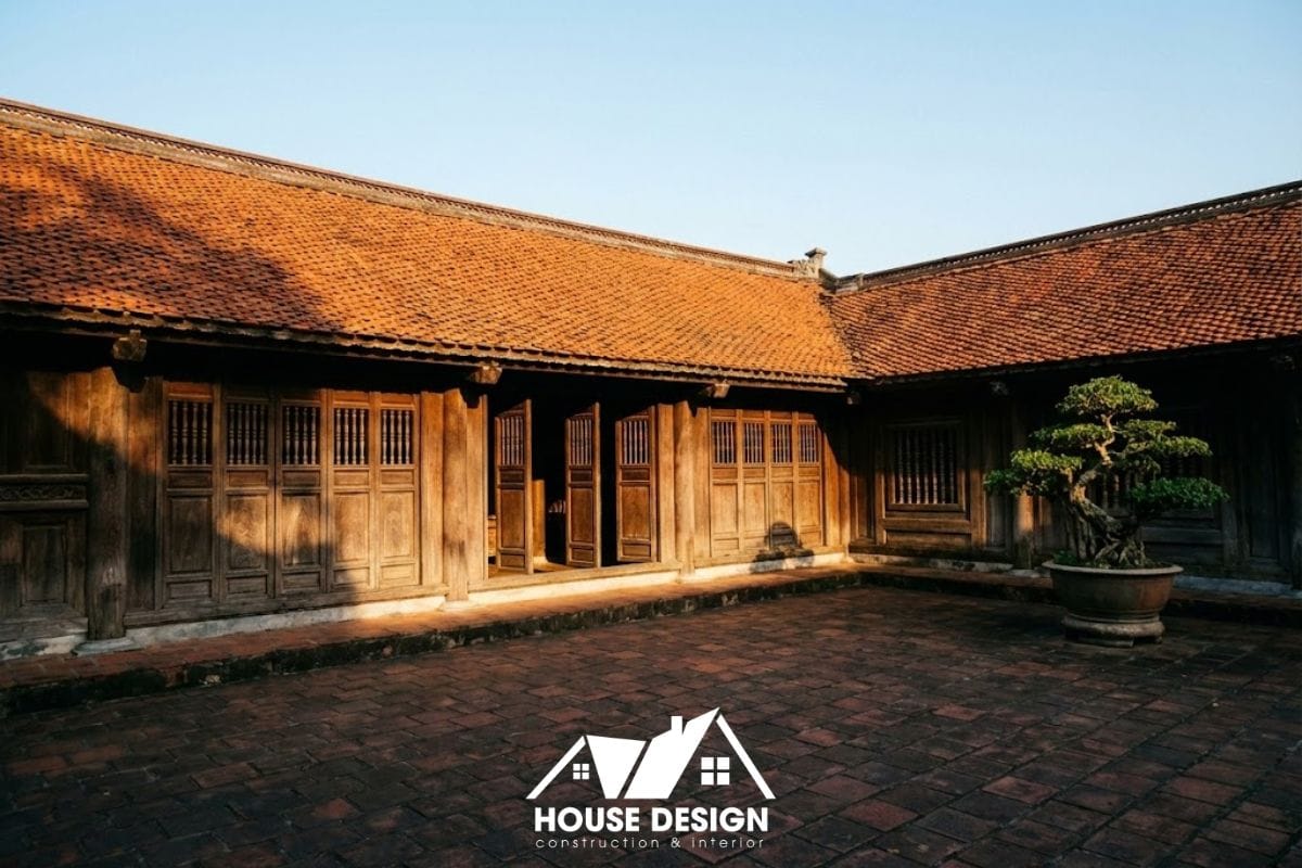 Mặt tiền nhà gỗ 3 gian sau phục dựng với mái ngói mũi hài đỏ tươi, sân gạch Bát Tràng và hệ cửa bức bàn truyền thống.